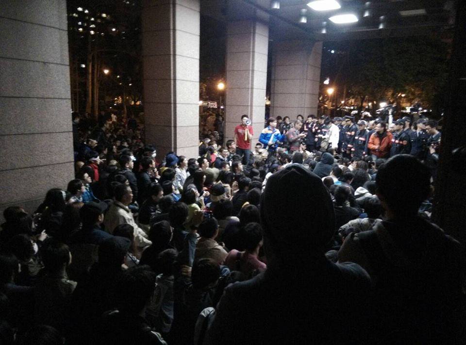 一百多名學生聚集於證門前靜坐抗議。